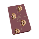 Maroon pet wrapping paper with dog portraits and a golden ribbon design.